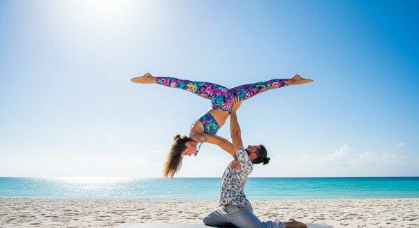 couple doing acrobatic yoga in beach