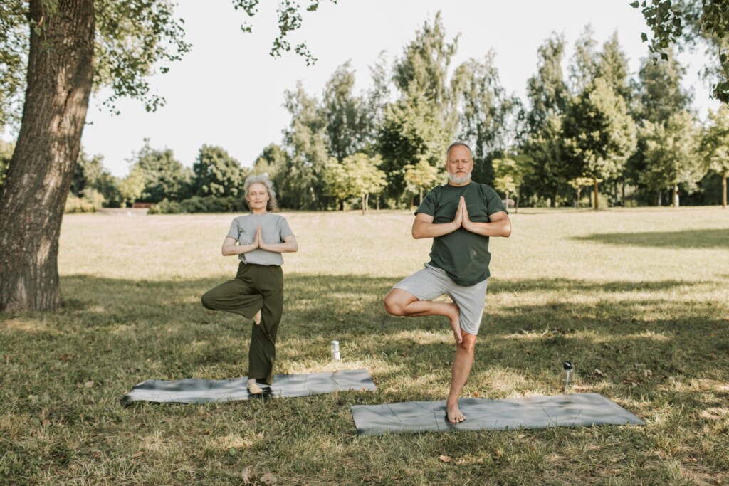 senior couple doing tree pose yoga