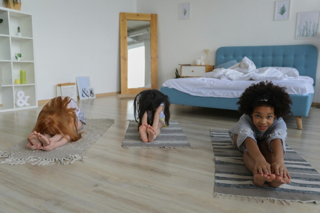 People performing a variation of Paschimottanasana (Seated Forward Bend), sitting with legs extended straight and reaching both hands towards the feet, while maintaining a deep stretch in the back, hamstrings, and calves. The variation may involve different arm positions or a deeper fold, enhancing flexibility and promoting relaxation